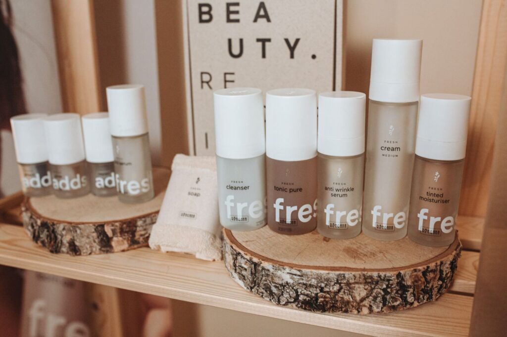 Productos de cuidado facial RINGANA con los ADDS sobre una repisa de madera