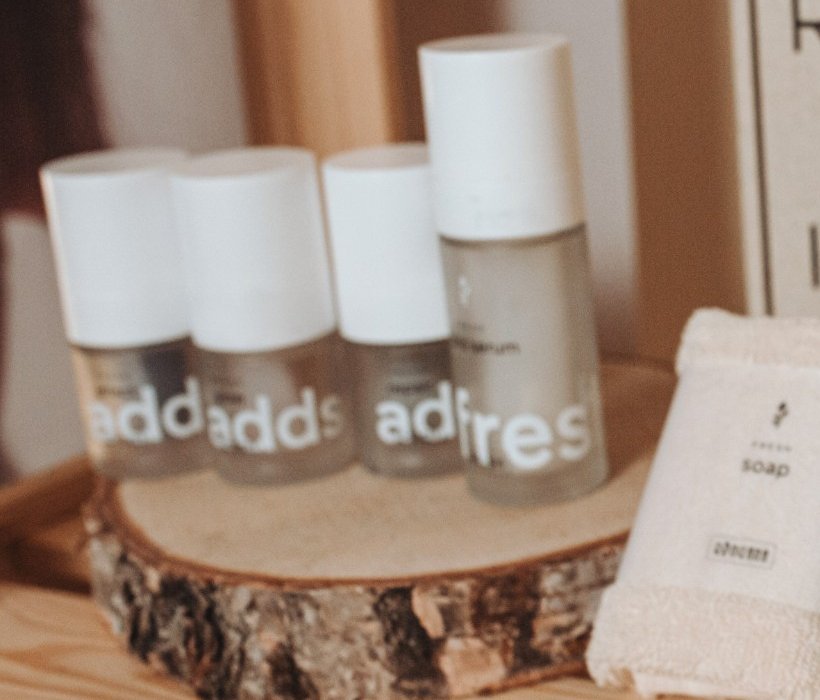 RINGANA ADDS glow, effect y repair junto a un sérum sobre un tronco de madera